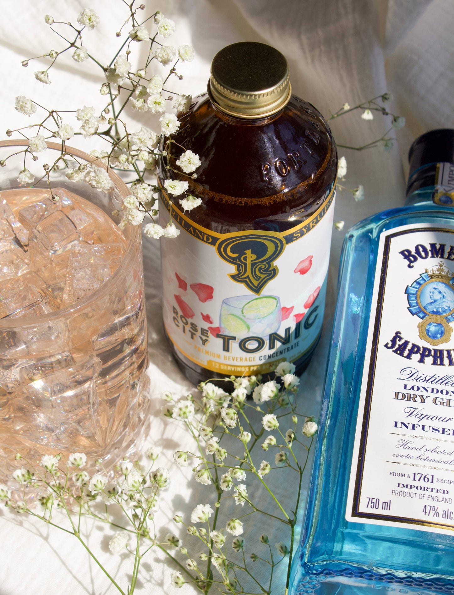 Bottle of tonic water and blue bottle with floral decorations