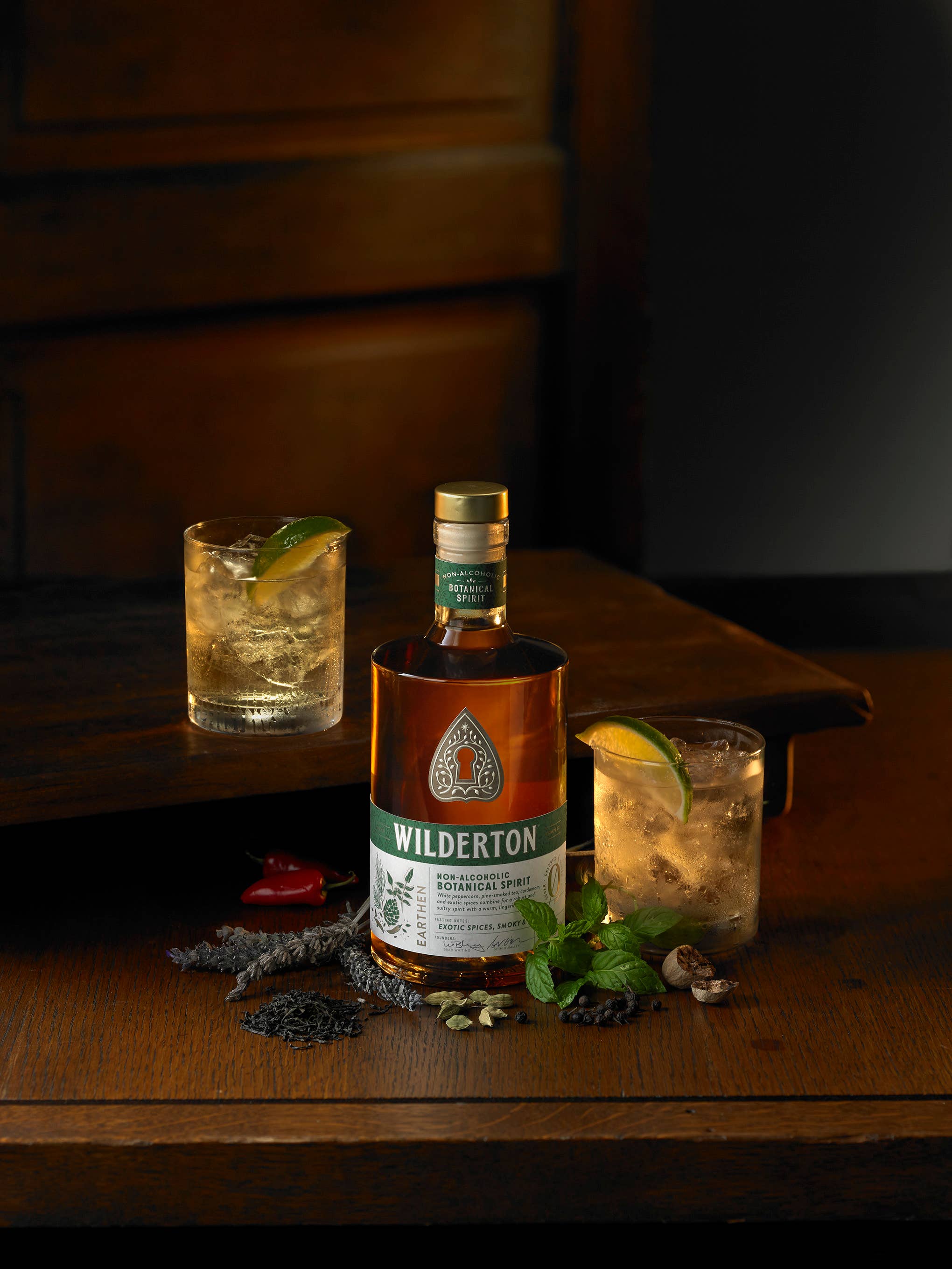Wilderton bottle with two cocktails on a wooden surface
