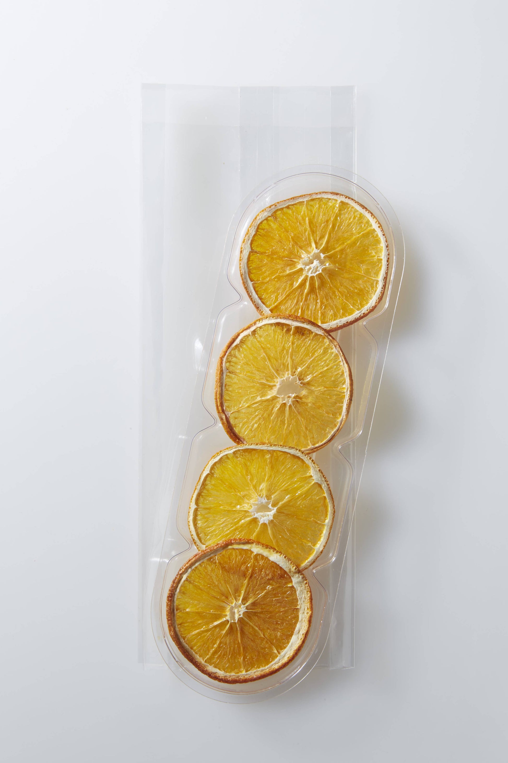 Packaged dried orange slices on a white background