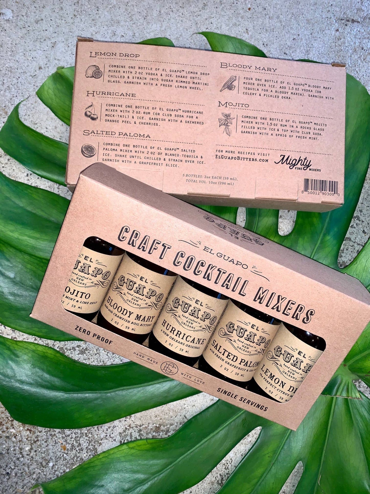 Box of craft cocktail mixers with labels on a green leaf background