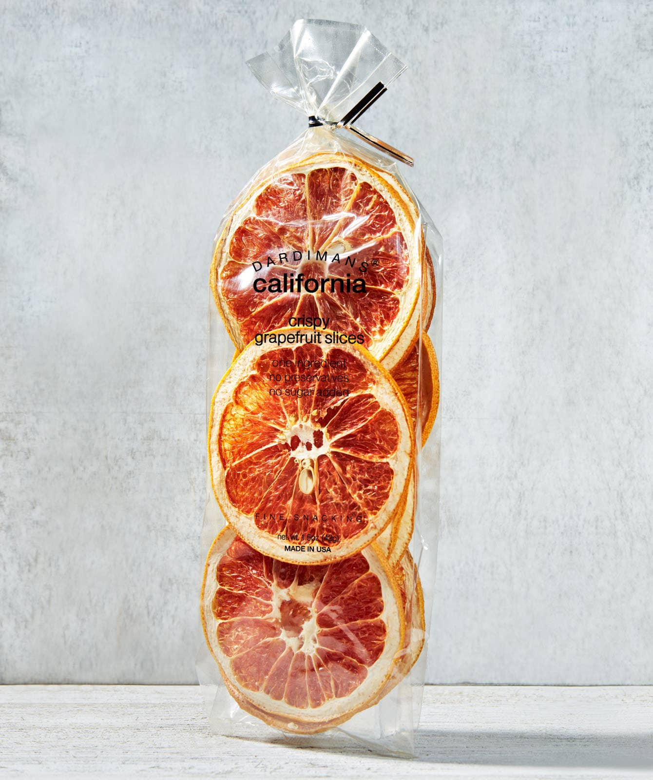 Packaged dried grapefruit slices with 'Made in California' text on a light gray background